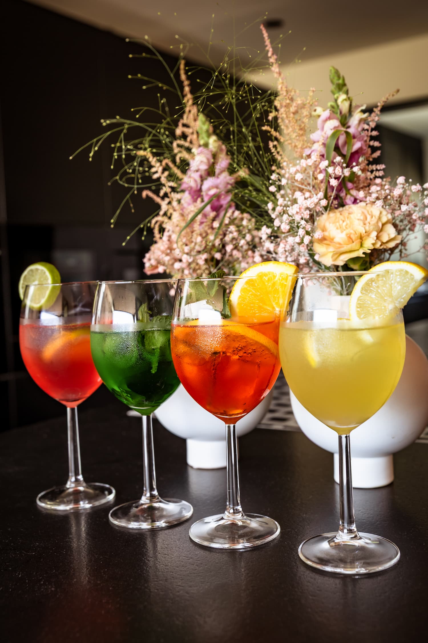 Four colourful cocktails in a row at a wedding