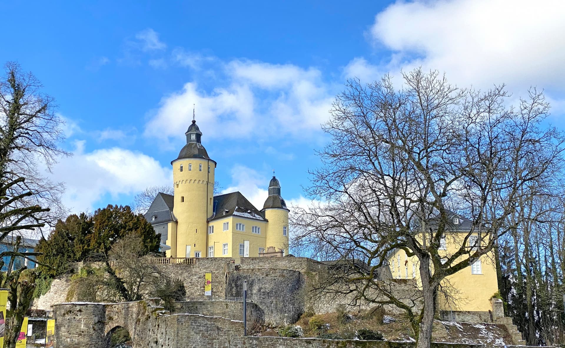 Schloss Homburg in Nümbrecht, Germany – historic castle with pale yellow walls and stone fortifications under a blue sky